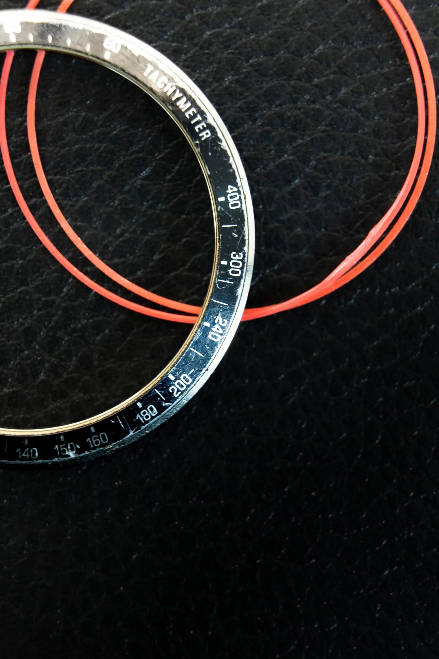 Certina tachymeter bezel and red case gaskets laid out during a service