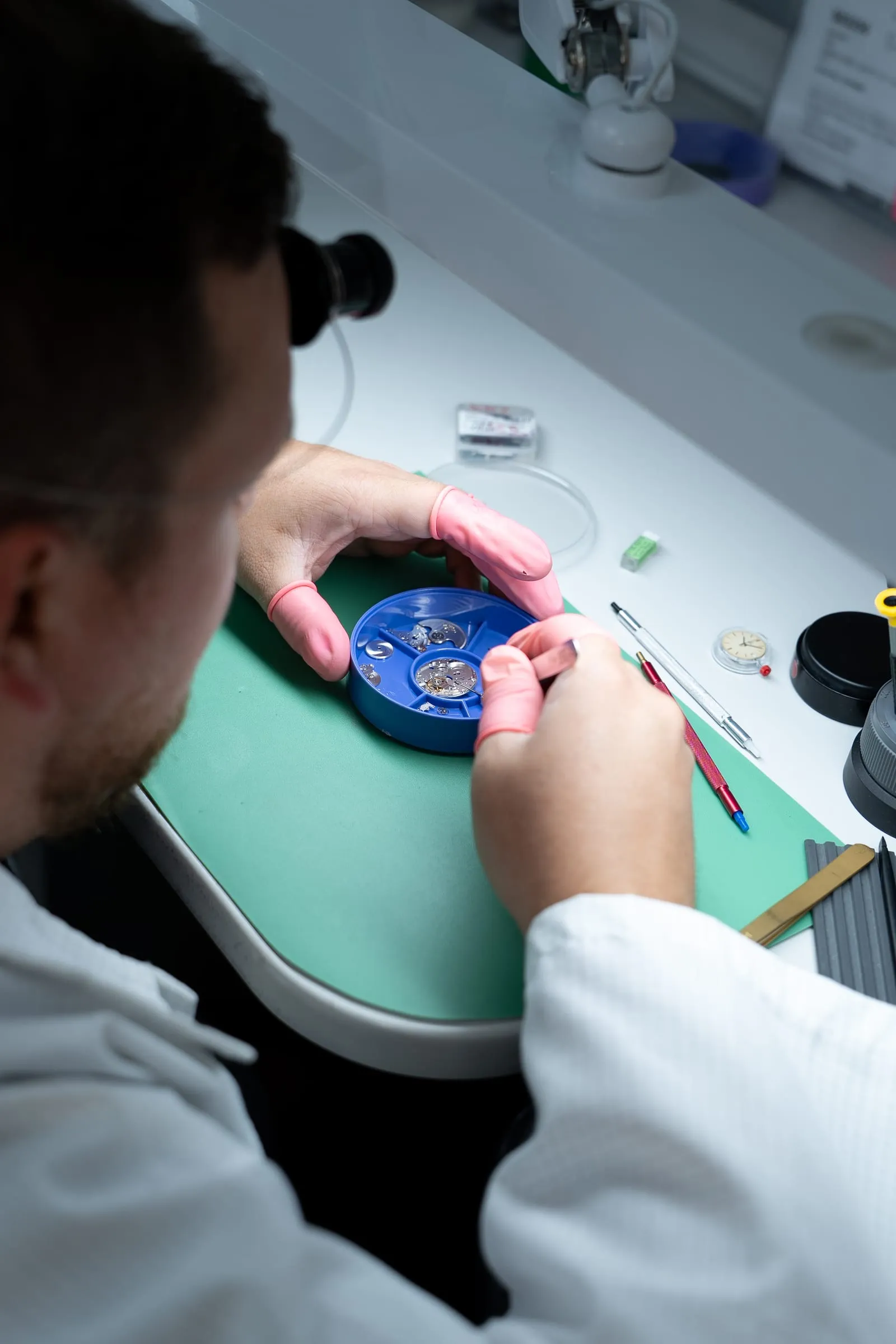 SwissMade watchmaker inspecting a movement during diagnosis