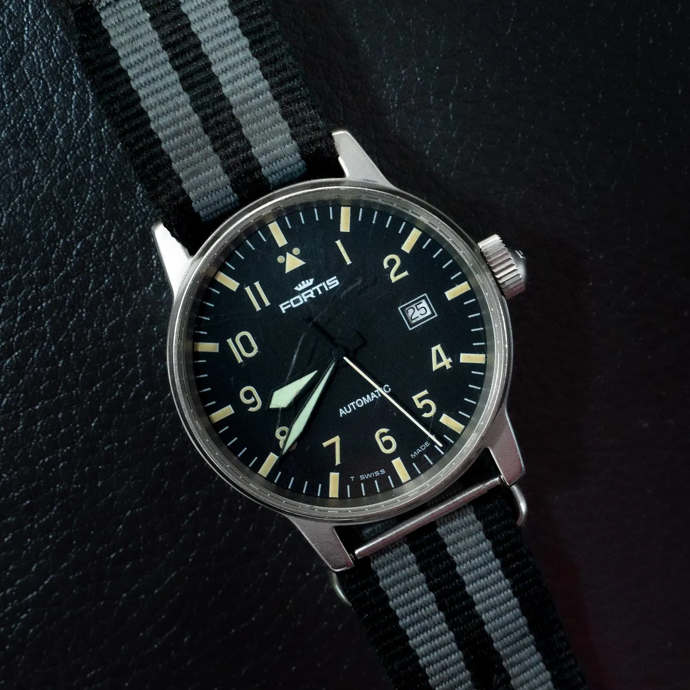 Fortis Flieger pilot watch with black dial on a striped NATO strap at SwissMade
