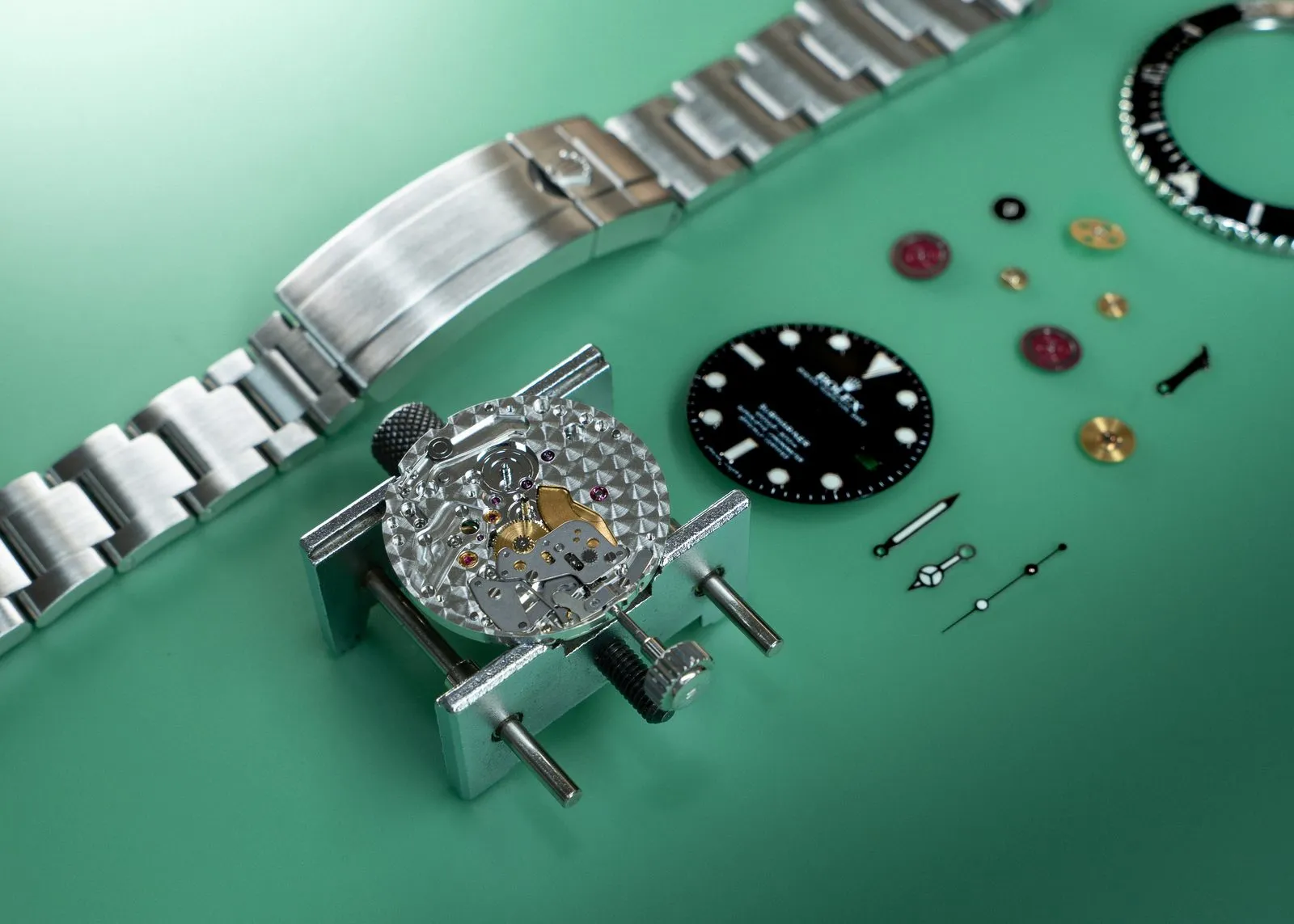 Rolex movement, dial and bracelet laid out on the bench during a full service at SwissMade