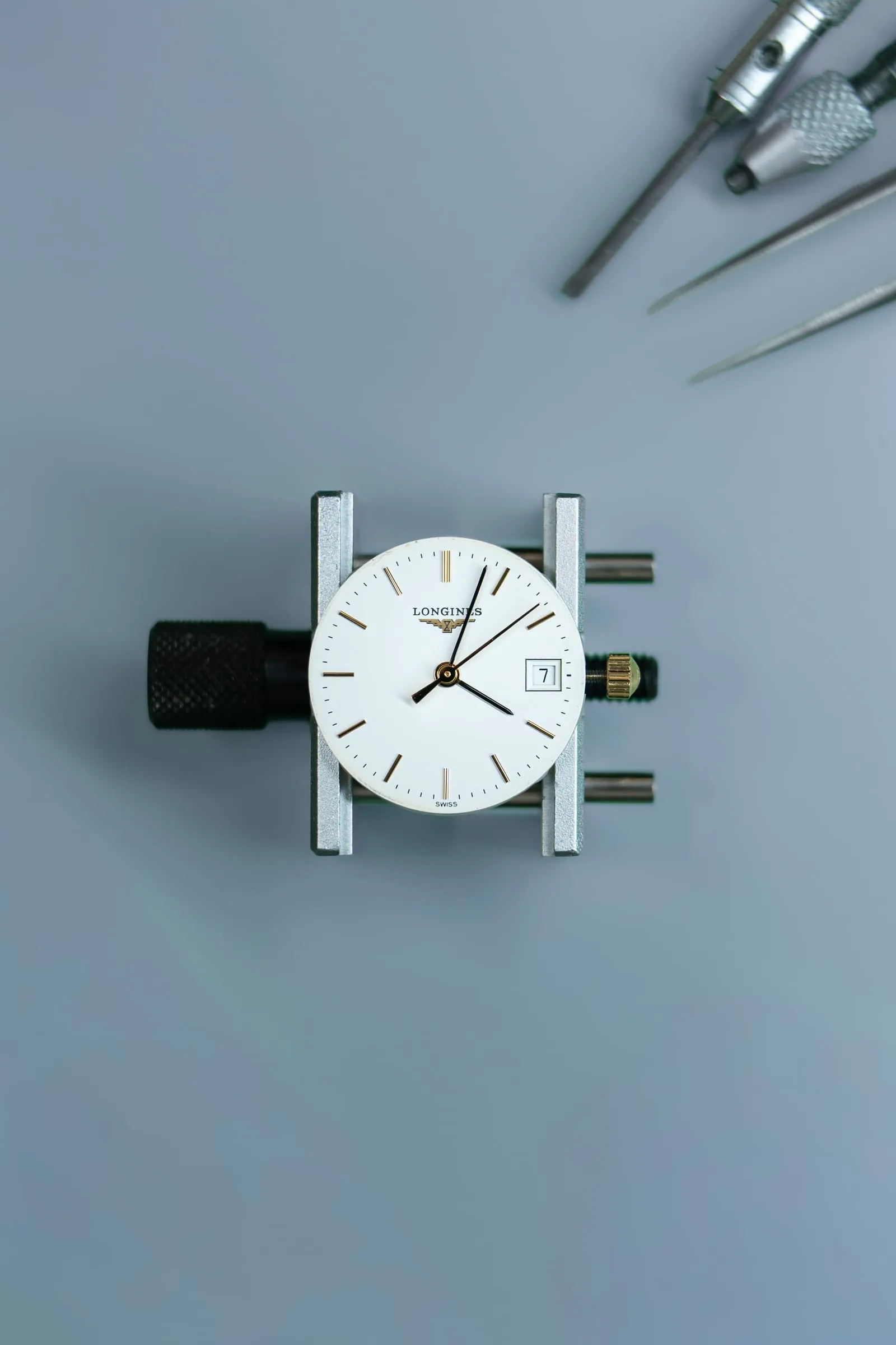 Longines Conquest dial held in a movement holder at SwissMade