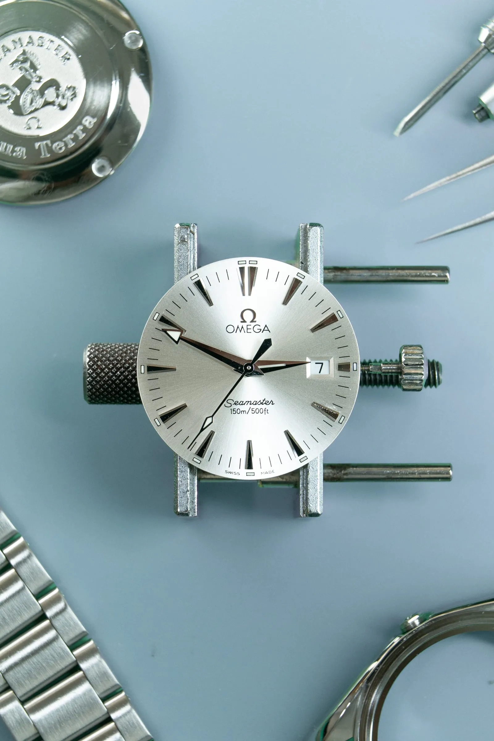 Omega Seamaster dial held in a movement holder on the SwissMade bench