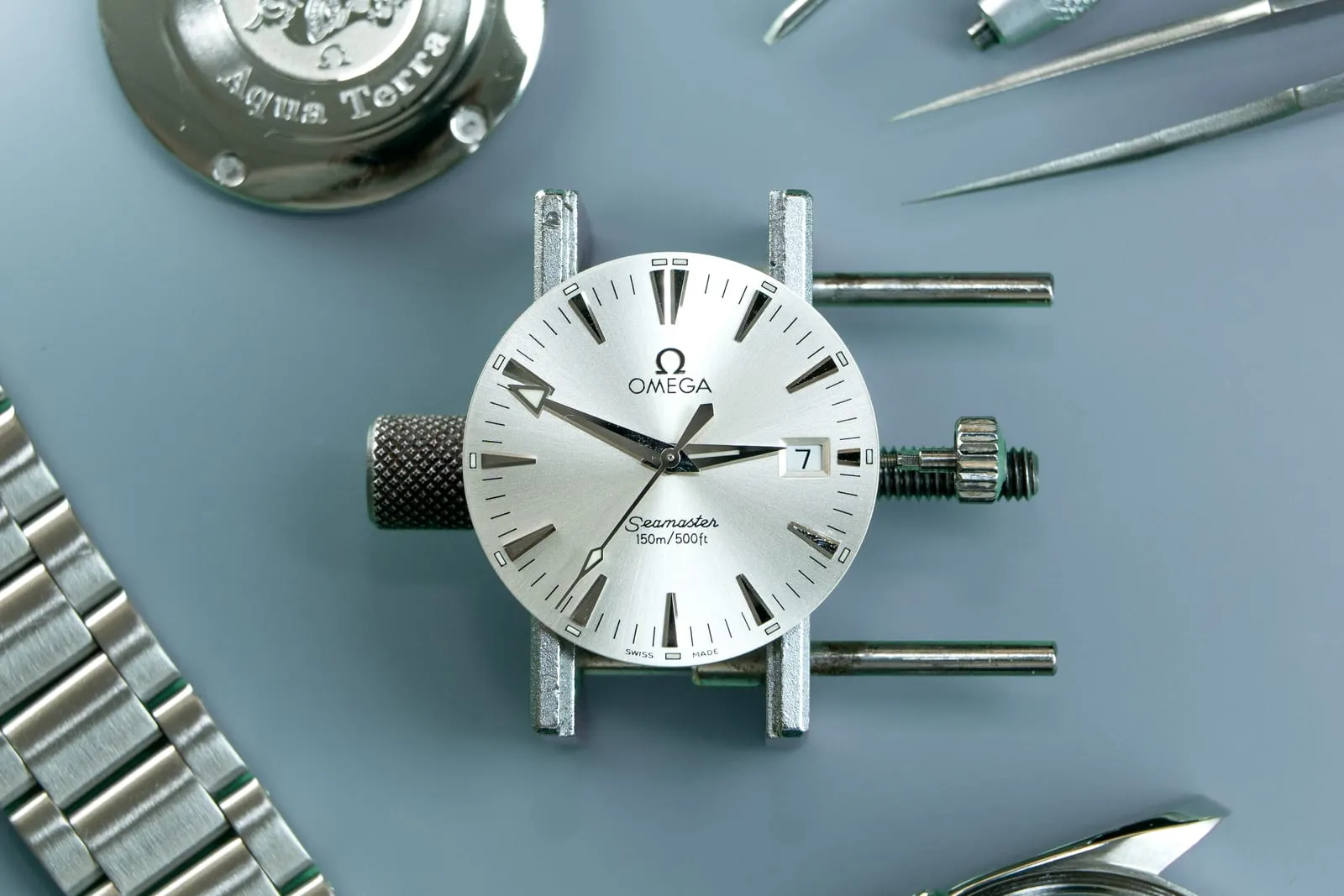Vintage Omega Seamaster in a movement holder during restoration at SwissMade