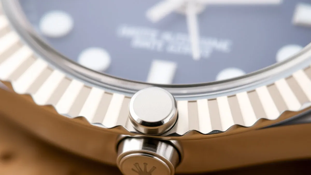 Close-up of a Rolex crown being unscrewed in the winding position