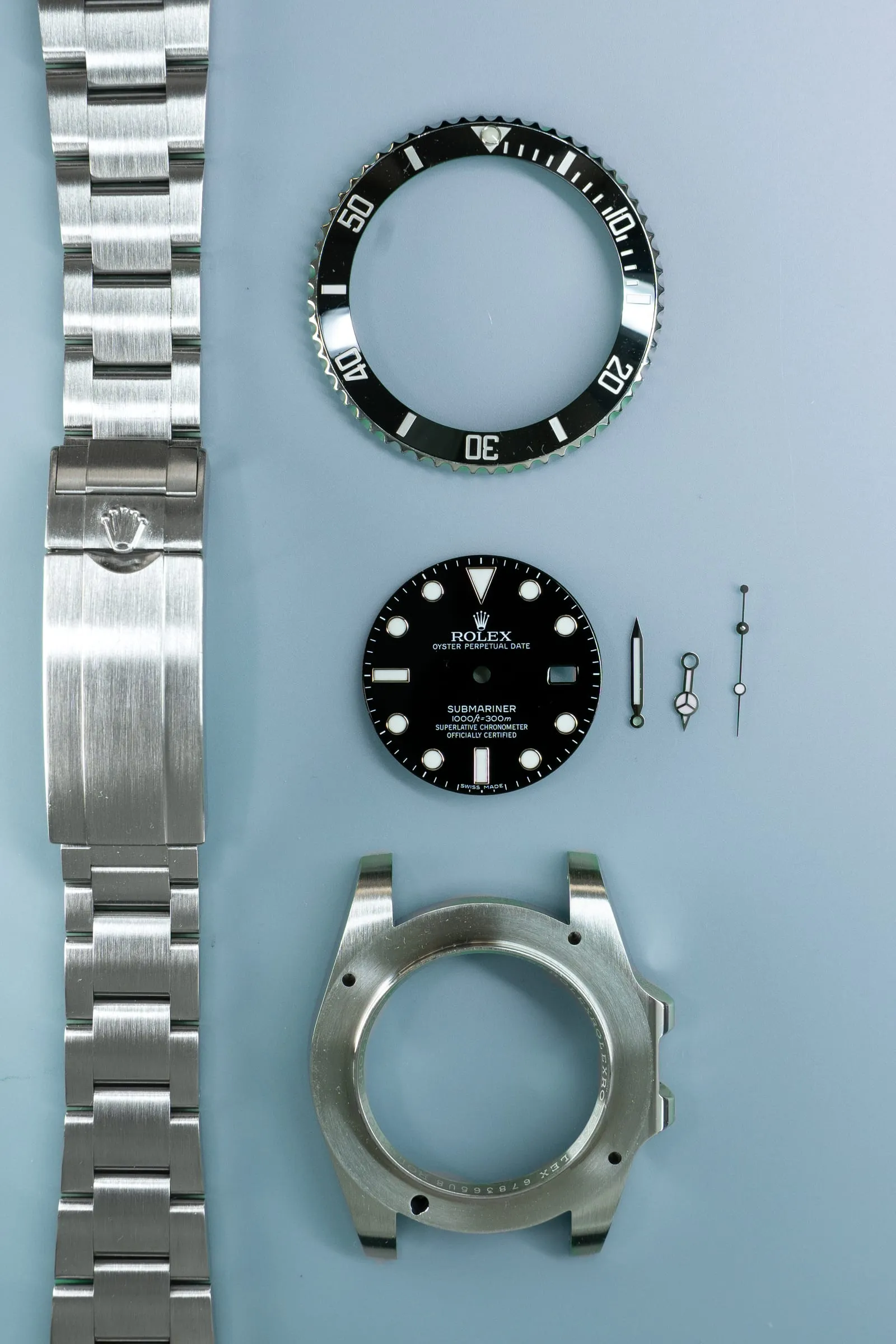 Rolex Submariner case, dial, bezel and bracelet laid out during a service at SwissMade