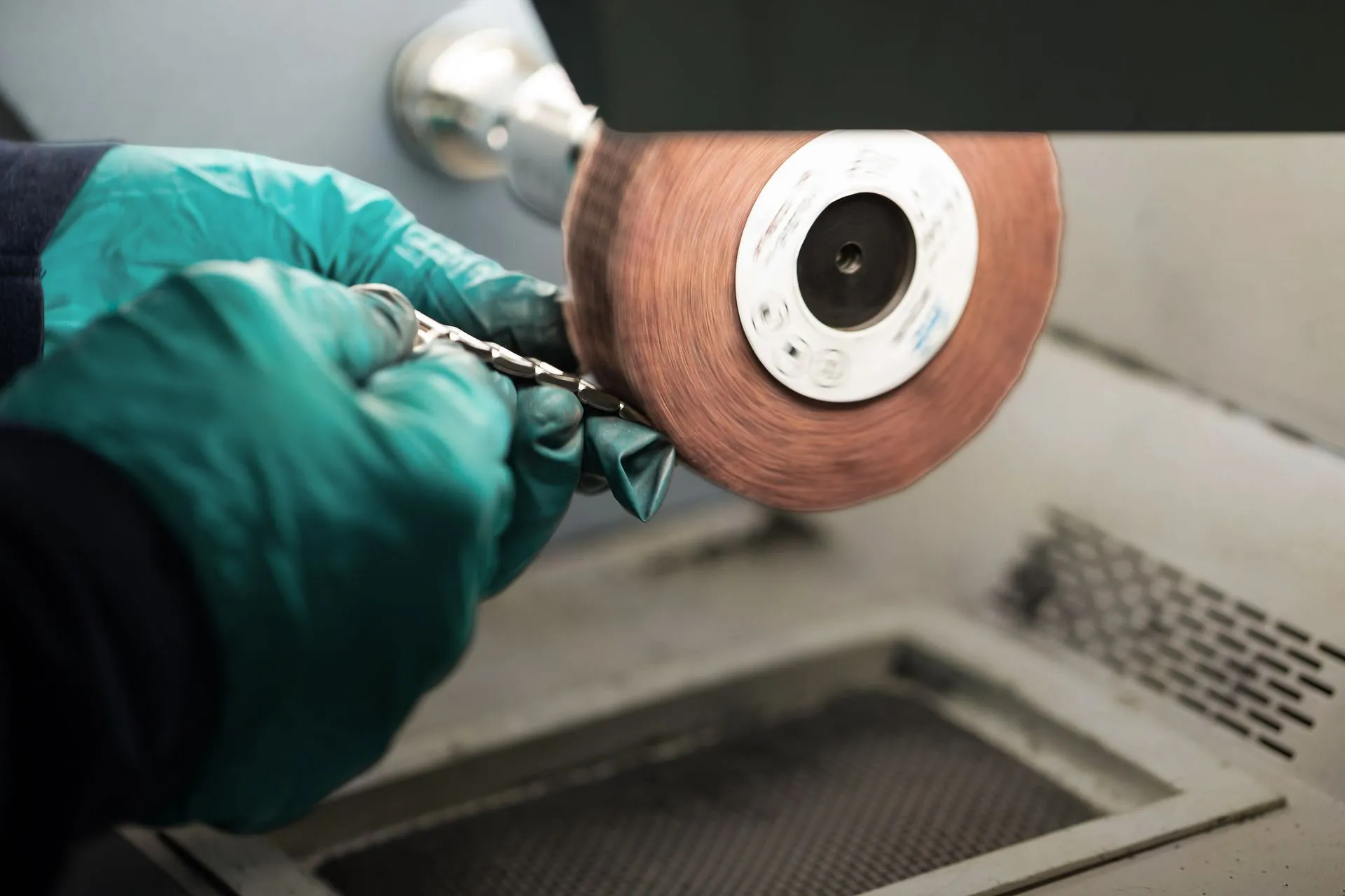 Watch case held against the polishing wheel in the SwissMade refinishing department