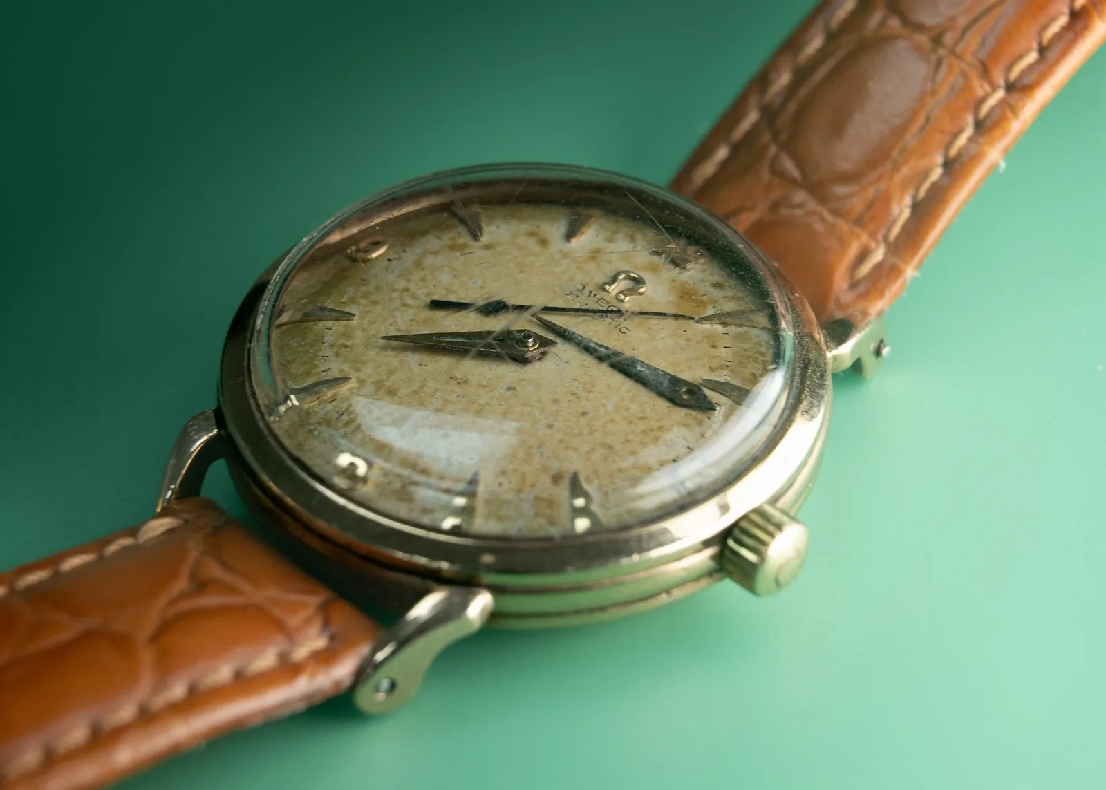 Vintage Omega with a patinated dial on a tan leather strap awaiting restoration at SwissMade